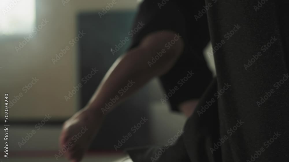 Man in boxing gloves kicks with all might into punching bag with leg in sports club for wrestling. Pre-fight preparation and hard work to achieve good results Man in boxing gloves kicks with all might into punching bag with leg in sports club for wrestling. Pre-fight preparation and hard work to achieve good results