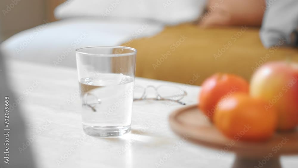 A Hand Placing a Glass of Water Onto the Table - Close Up A Hand Placing a Glass of Water Onto the Table - Close Up