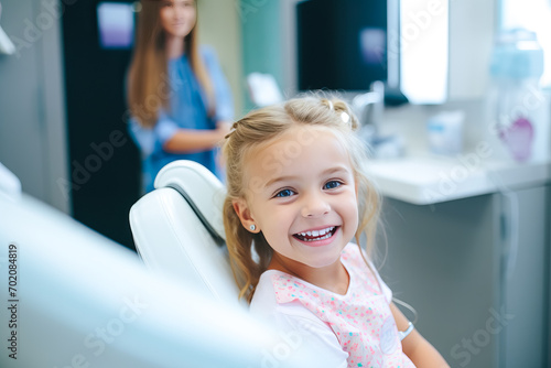 Little smiling girl sitting on dental chair. Professional stomatology for kid. Teeth healthcare