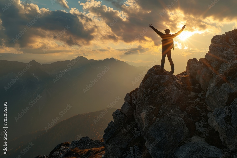 Sunrise triumph: A happy man reaches new heights, standing tall on a mountain summit, embracing the morning glow.