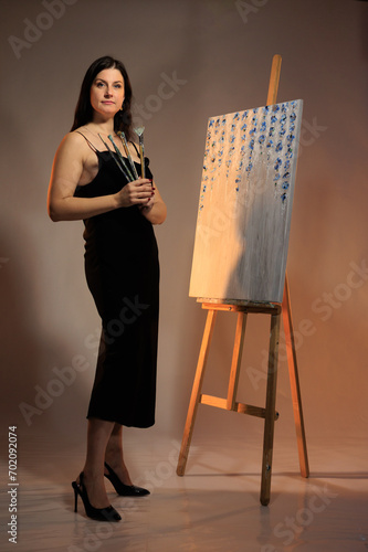 female artist paints a picture in the studio photo