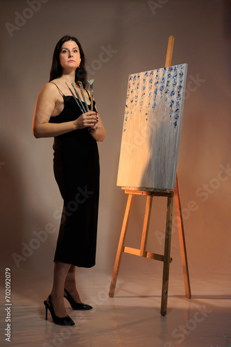 female artist paints a picture in the studio photo