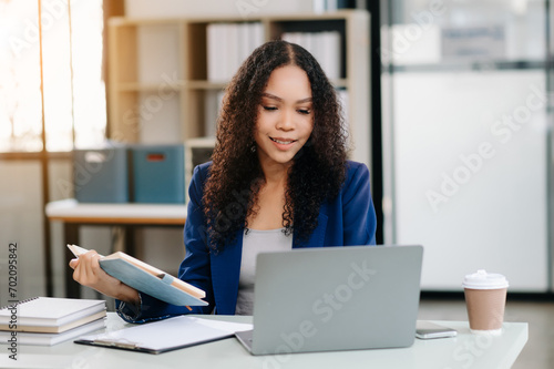 Businesswoman Analyzing Finance on Tablet and Laptop at modern Office Desk tax, report, accounting, statistics © Nuttapong punna