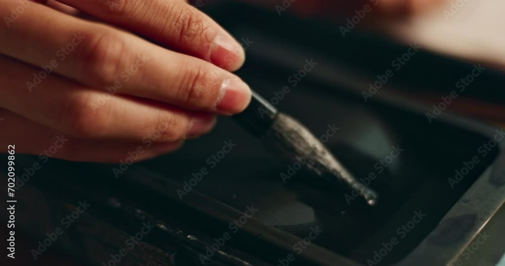 Hand, closeup of brush in ink for writing and calligraphy or ancient stationery for art and inkstone. Japanese creativity, black paint with paintbrush and person stroke with traditional vintage tools Hand, closeup of brush in ink for writing and calligraphy or ancient stationery for art and inkstone. Japanese creativity, black paint with paintbrush and person stroke with traditional vintage tools