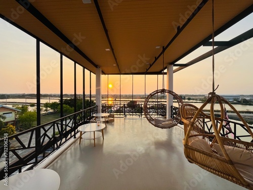 Wooden pallet furniture and hanging swing chair at sunset