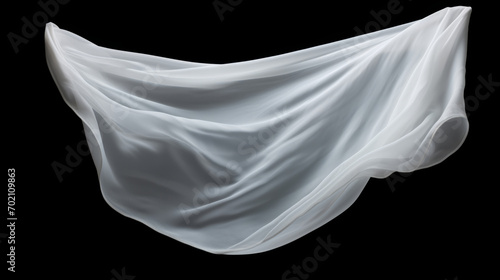 White cloth that is floating and hiding something unknown underneath. Fabric isolated on black background. 