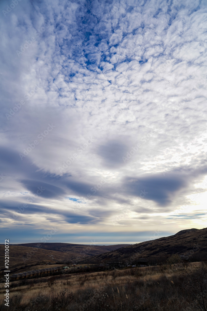 Fototapeta premium landscape in a hilly area with white clouds.