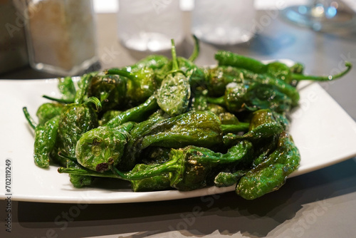 Blistered Padron peppers (Pimientos de Padrón), small green pepper in Canola and olive oil- traditional classic Spanish Tapas photo