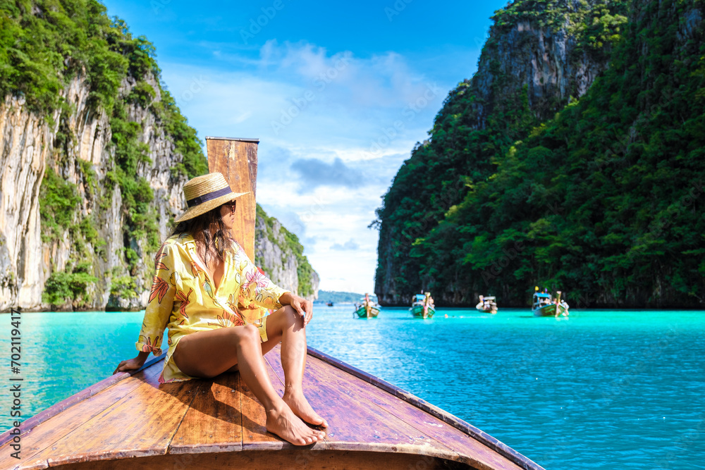 Asian women in front of a longtail boat at Kho Phi Phi Thailand - obrazy, fototapety, plakaty 