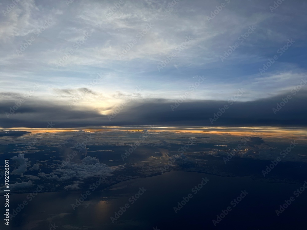 Fototapeta premium Sunrise above clouds from airplane window