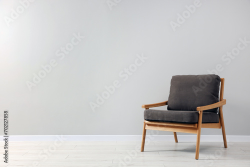 Comfortable armchair near light grey wall indoors. Space for text