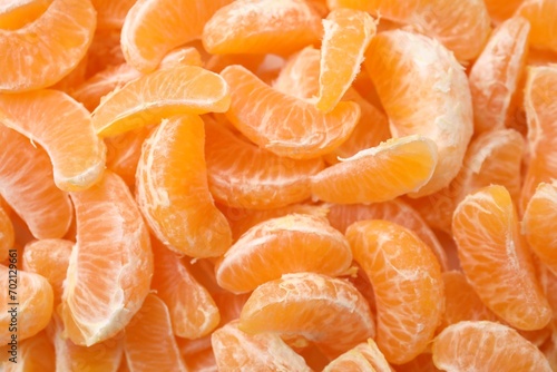 Segments of tasty tangerines as background, top view