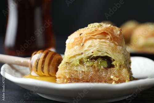 Delicious fresh baklava with chopped nuts and honey on table, closeup. Eastern sweets