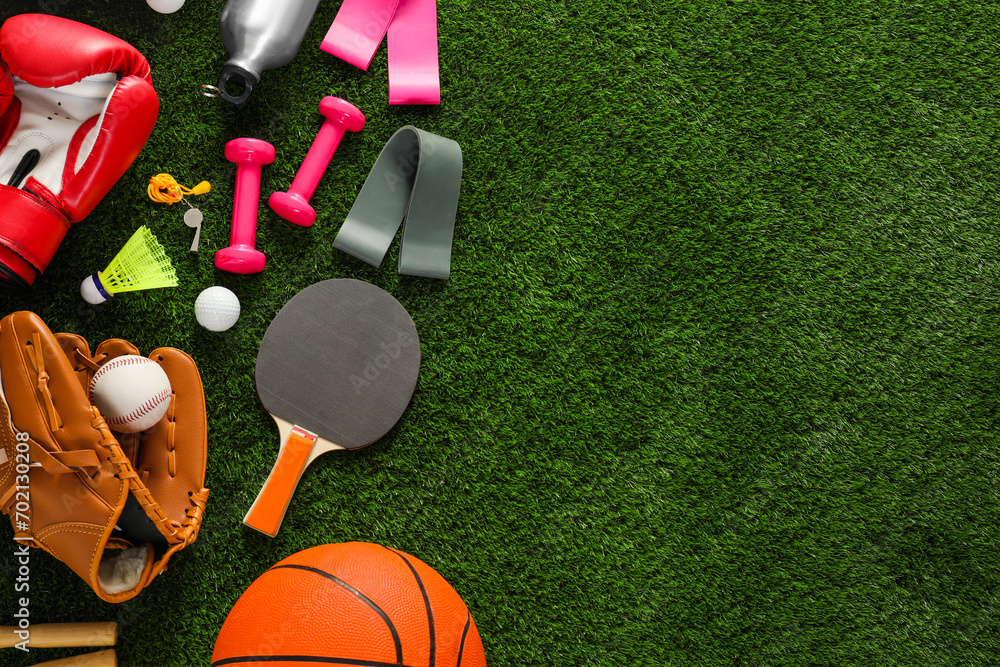 Naklejka premium Different sport equipment on green grass, flat lay. Space for text