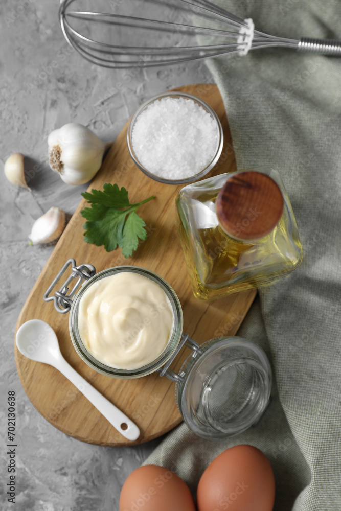 Tasty mayonnaise in jar, ingredients and whisk on gray table, flat lay Tasty mayonnaise in jar, ingredients and whisk on gray table, flat lay