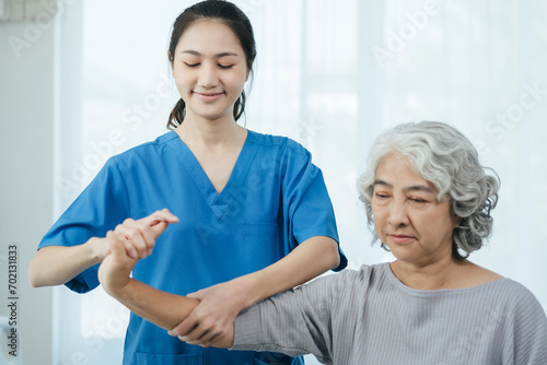 senior woman doing exercise at clinic with physiotherapist. help of a personal trainer during a rehabilitation session.