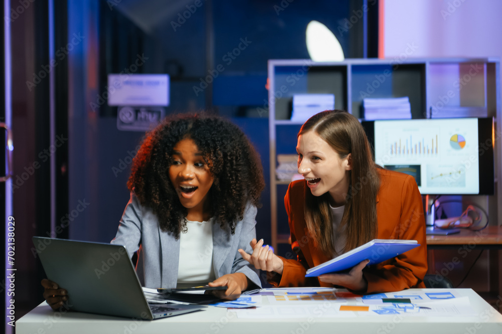 Happy businesspeople while collaborating on a new project in an office. Two businesspeople using a laptop and tablet Happy businesspeople while collaborating on a new project in an office. Two businesspeople using a laptop and tablet