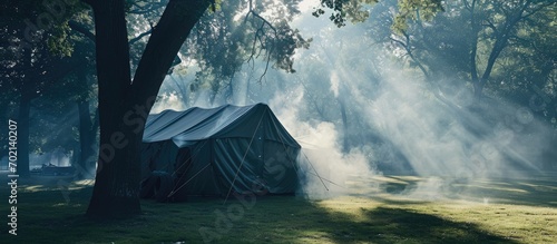 Big military camp tent with smoke rescuer firefighter training site in Park on summer day. with copy space image. Place for adding text or design photo