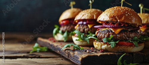 a group of mini burgers on a wooden board. with copy space image. Place for adding text or design