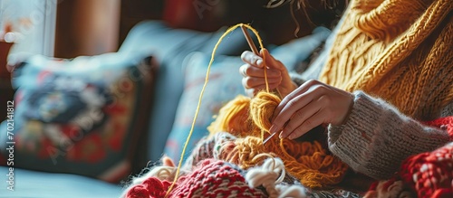 Adult attractive woman at home in knitting work activity using colorful wool Happy and relaxed female people enjoying time indoor on the sofa Knit job. with copy space image