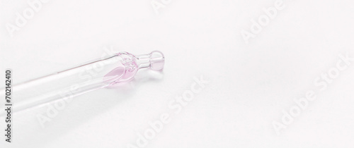 Cosmetic pipette with pink gel, serum, serum on a light background.