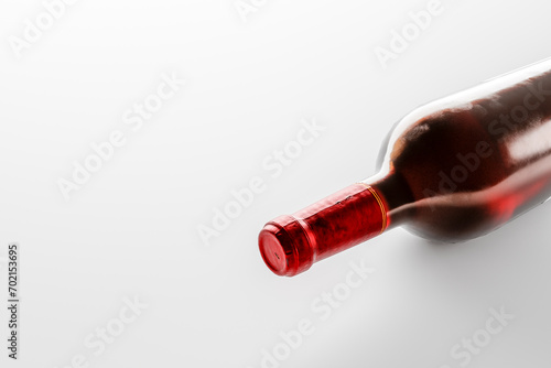 A bottle of red wine lies on a white background. © sv_production