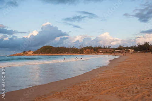 evening mood at Tofo Beach in Mozambique with people bathing in the back photo