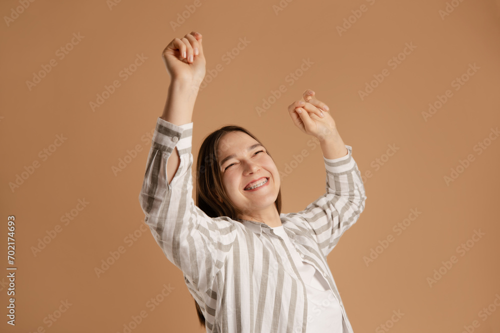 young woman dancing on beige background, enjoy health with brace system young woman dancing on beige background, enjoy health with brace system