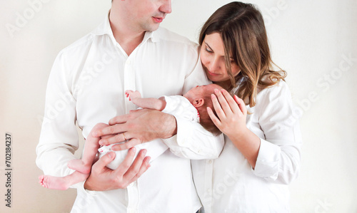 Young happy parents with cute newborn baby daughter