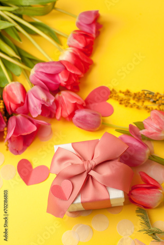 Fototapeta Naklejka Na Ścianę i Meble -  Romantic background with bouquet of tulips and gift boxes on yellow. Top view with copy space. Mother's Day, 8 march, Saint Valentine day background, greeting card