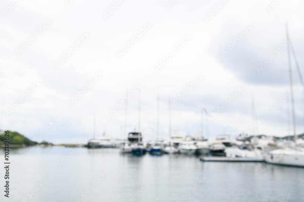 Blurred background sailing yachts in marina. Summer abstract defocused background. Yachting concept.