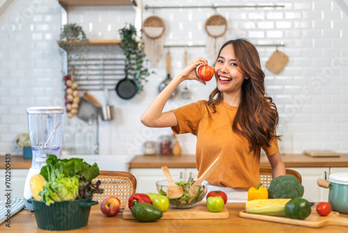 Portrait of beauty body slim healthy asian woman big smile cooking and preparing vegan food healthy holding apple, red apple, dental, teeth, fruit in kitchen at home.Diet.Fitness, healthy food
