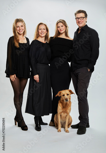 Studio Family Portrait with mother, father, two daughters and a dog photo