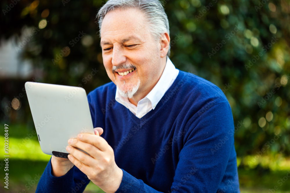 Senior man enjoying technology in the park Senior man enjoying technology in the park