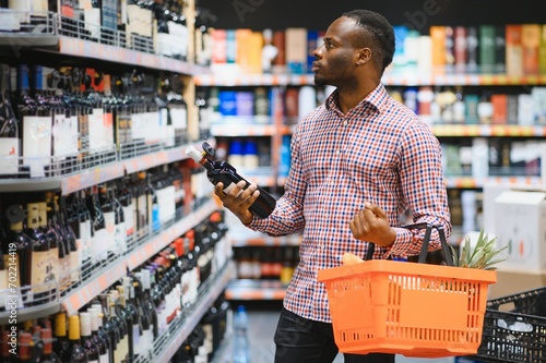 African American man in grocery store buying wine photo