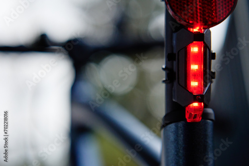 Glowing bicycle taillight. Red stop light for cyclist safety. Rear led light on bike photo