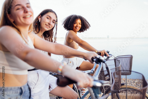 Teenagers of different nationalities and appearance on bicycles ride along a city street