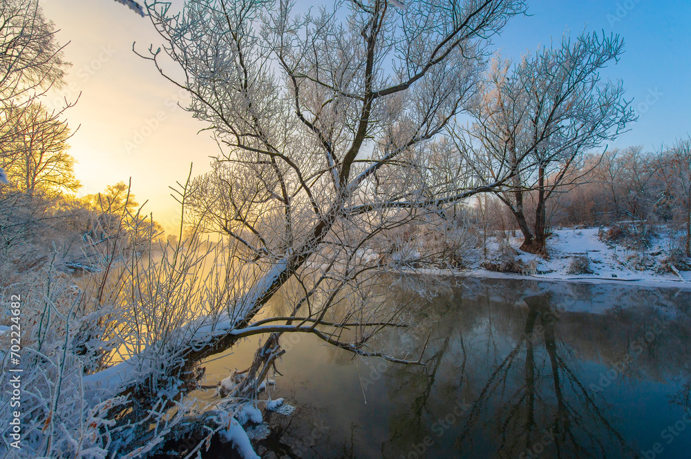 Enjoy the stunning beauty of nature's colors at sunrise. See how the sun illuminates the icy river with warm light. Be enchanted by the breathtaking spectacle of winter magic.