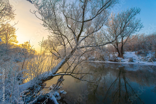 Enjoy the stunning beauty of nature's colors at sunrise. See how the sun illuminates the icy river with warm light. Be enchanted by the breathtaking spectacle of winter magic.