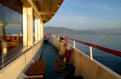 a scenic and tranquil nautical scenery with a white ship on lake Constance (Bodensee) against the sunny sky at sunset on a warm October evening (Bregenz, Austria)	