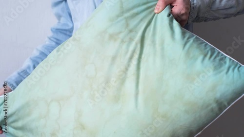Female hands change a pillowcase from dirty saliva stains on a pillow for longterm use cleaning 
