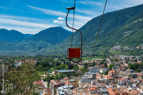 Der Sessel eines Sessellifts rückseitig vor Tal- und Bergpanorama
