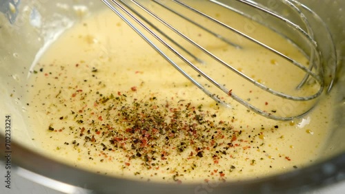 Cooking homemade mayonnaise sause adding black red ground pepper to metal bowl on kitchen. Cooking sauce for salad, meat dishes. Dressing for different dishes. Culinary, cuisine concept.