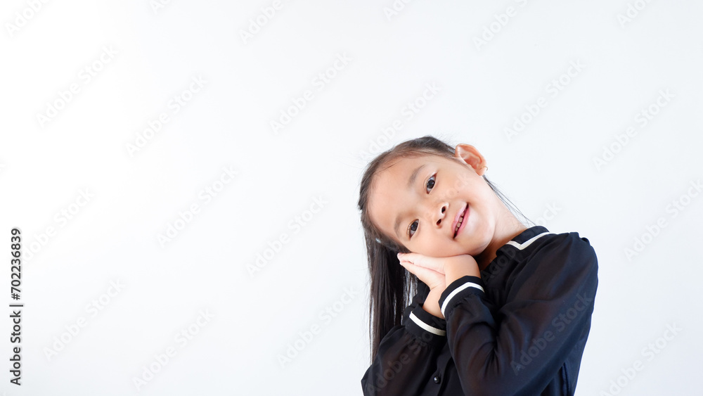 Closeup happy cute little Asian girl in black dress smiling over gray background Closeup happy cute little Asian girl in black dress smiling over gray background