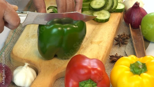 woman hands cutting green bell pepper with chefs knife on chopping board