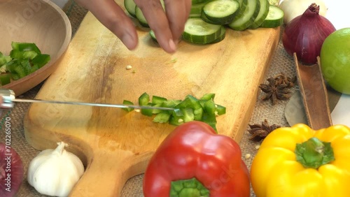 Woman take green pepper from wooden board