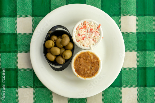 Delicious assortment of olives, farinheira pâté, and seafood pâté on a restaurant table. photo