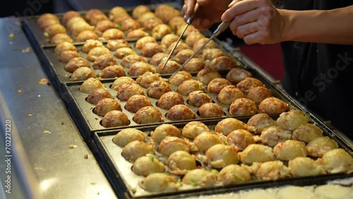 屋台で職人がたこ焼きを焼く映像