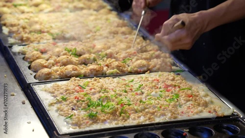 屋台で職人がたこ焼きを焼く映像