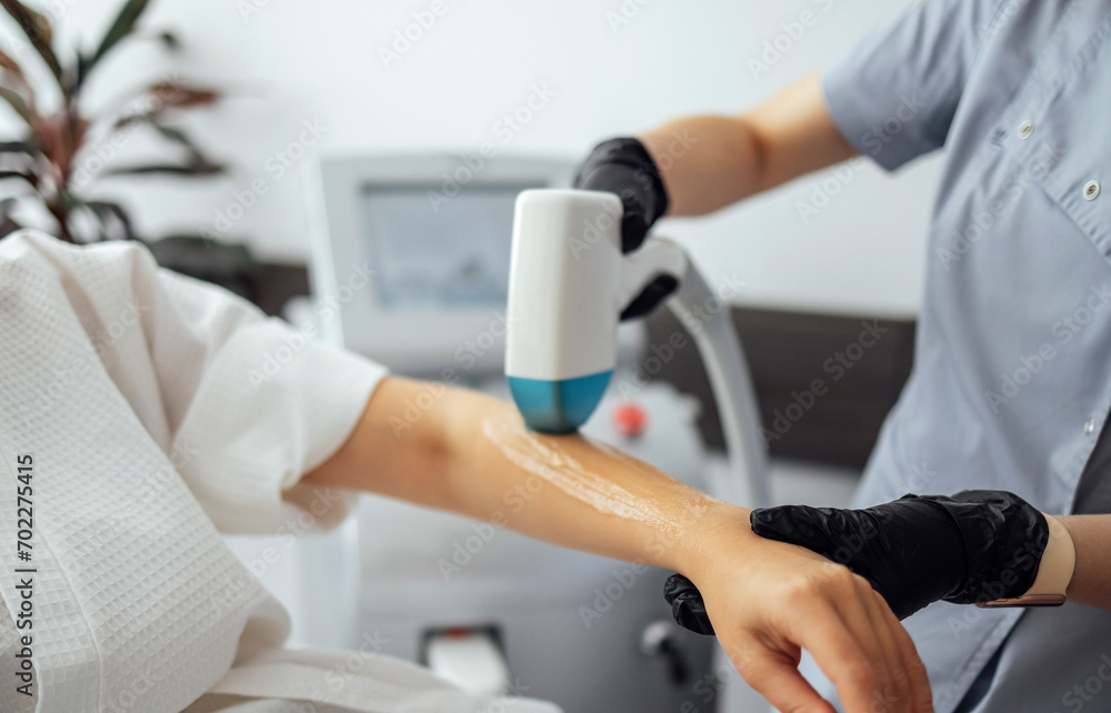 Young woman receiving photo epilation while visiting beauty center on salon
